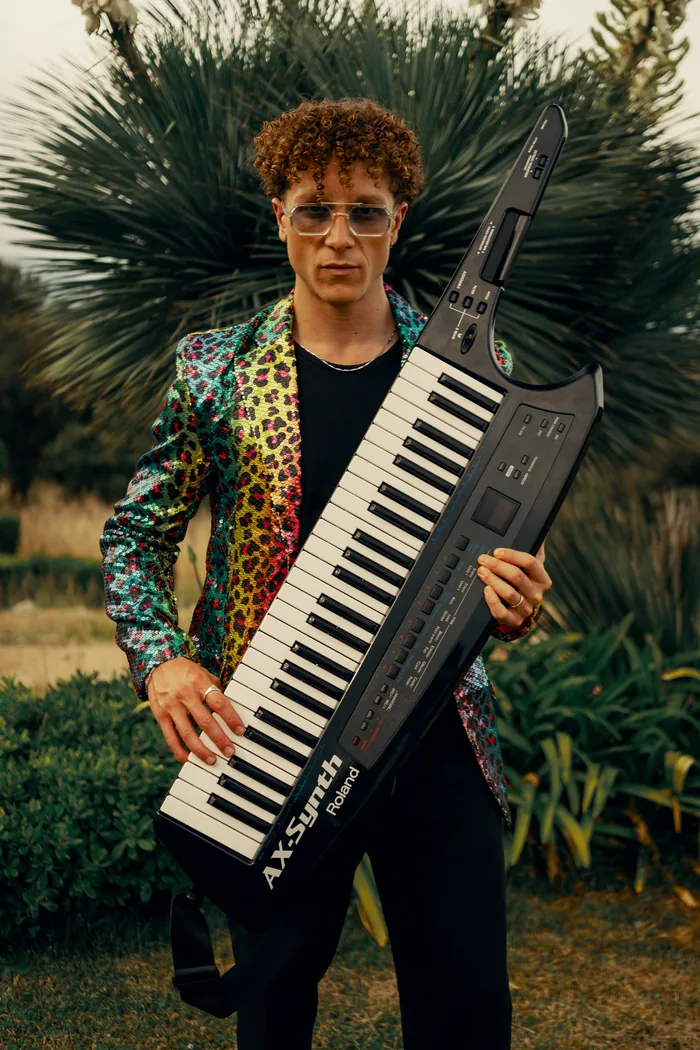 The Thrillers keytar player in a leopard-print jacket holding his keytar