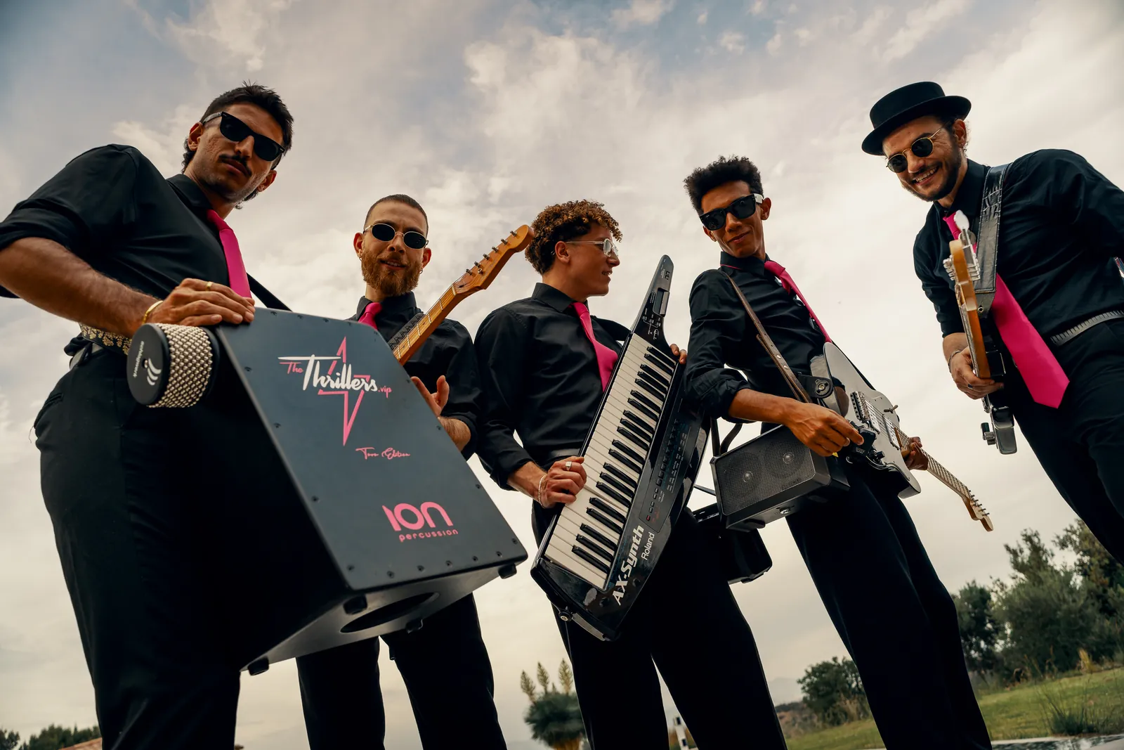 The Thrillers looking down at the camera, with their branded cajon and keytar